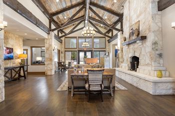 A dining room with a table and chairs in front of a stone fireplace